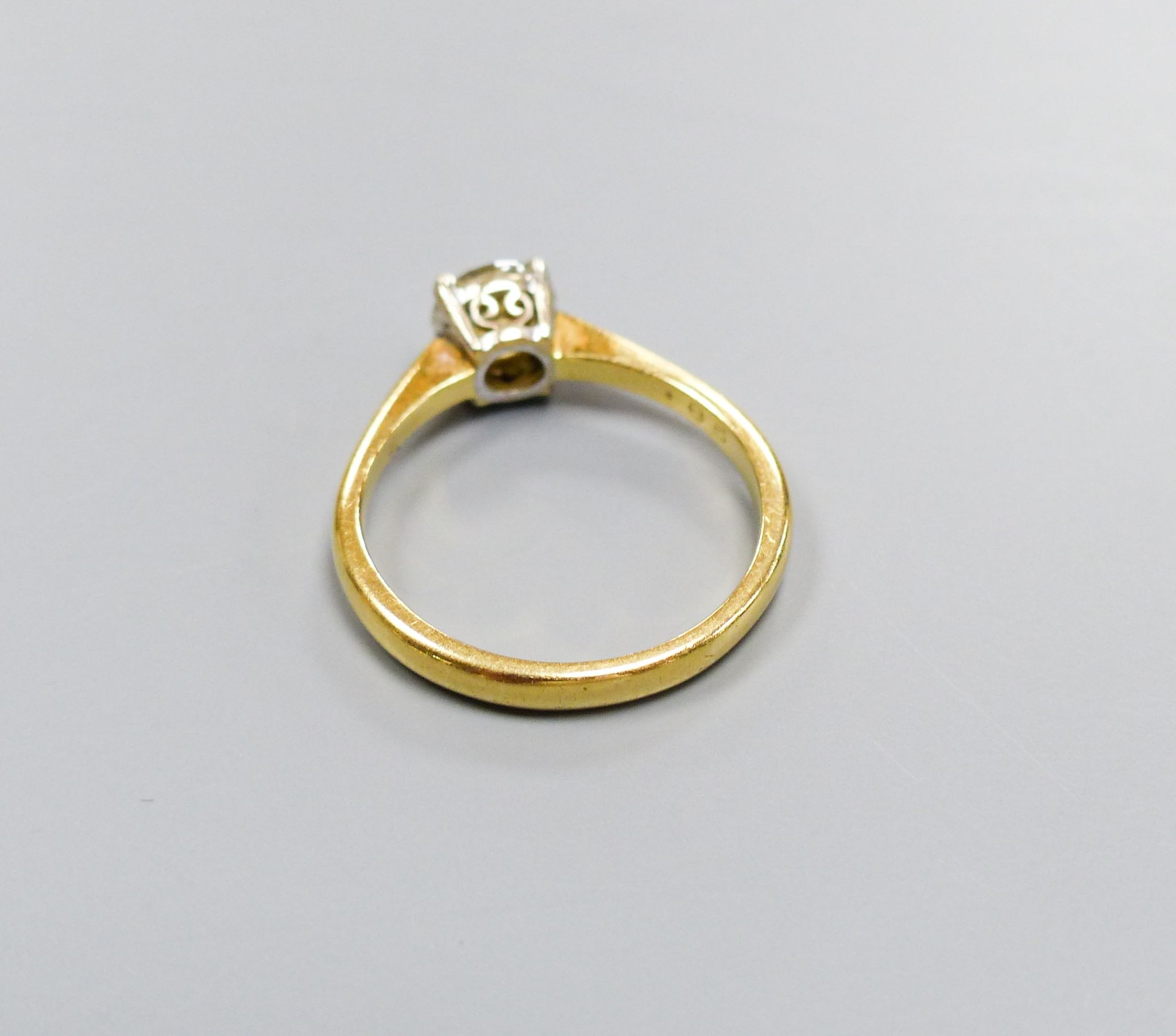 A modern 18ct gold and solitaire diamond ring, size O, gross 3.2 grams